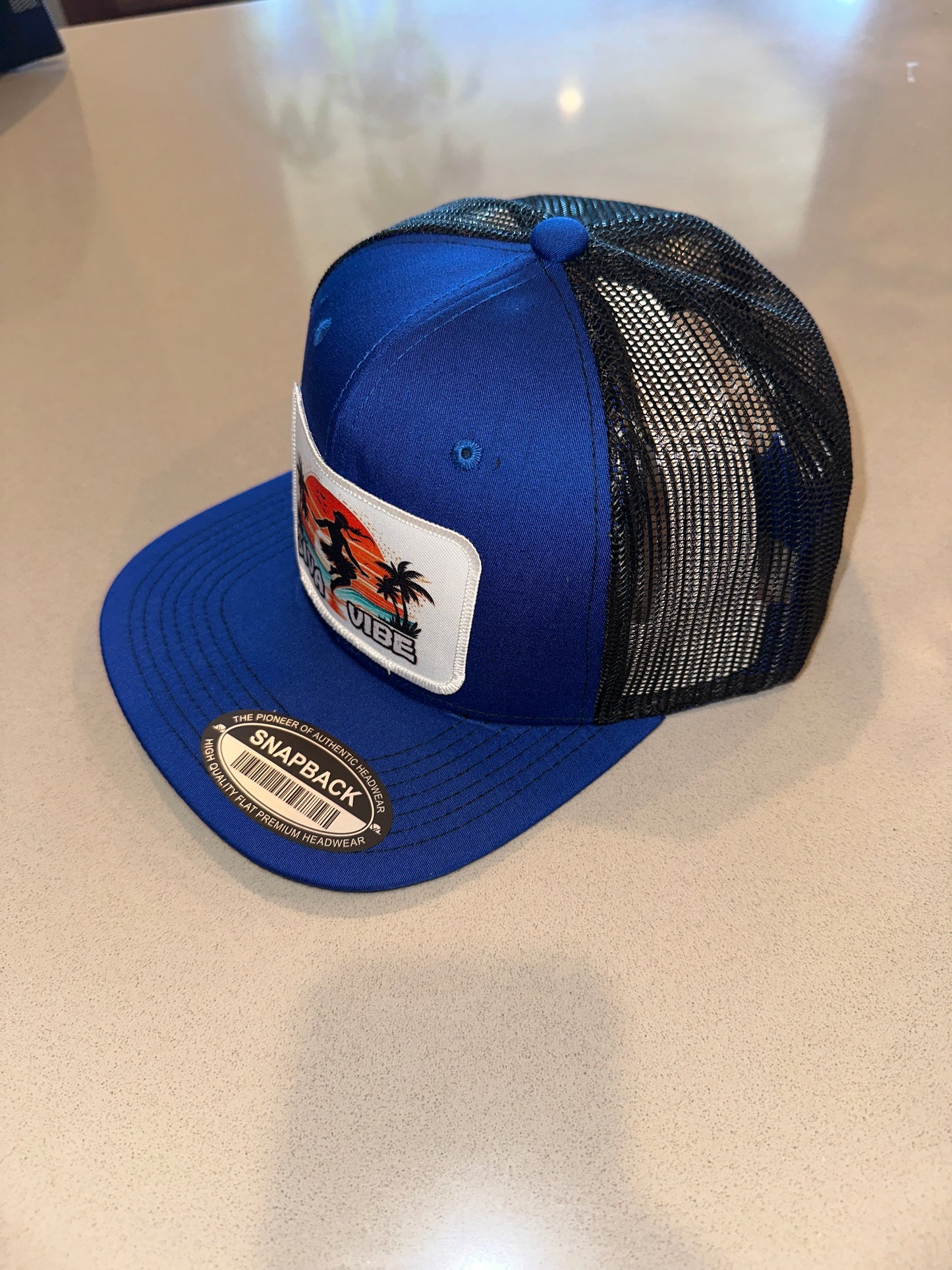Side view of Siva Vibe hip hop–style satin hat in royal blue — sleek look with cultural branding