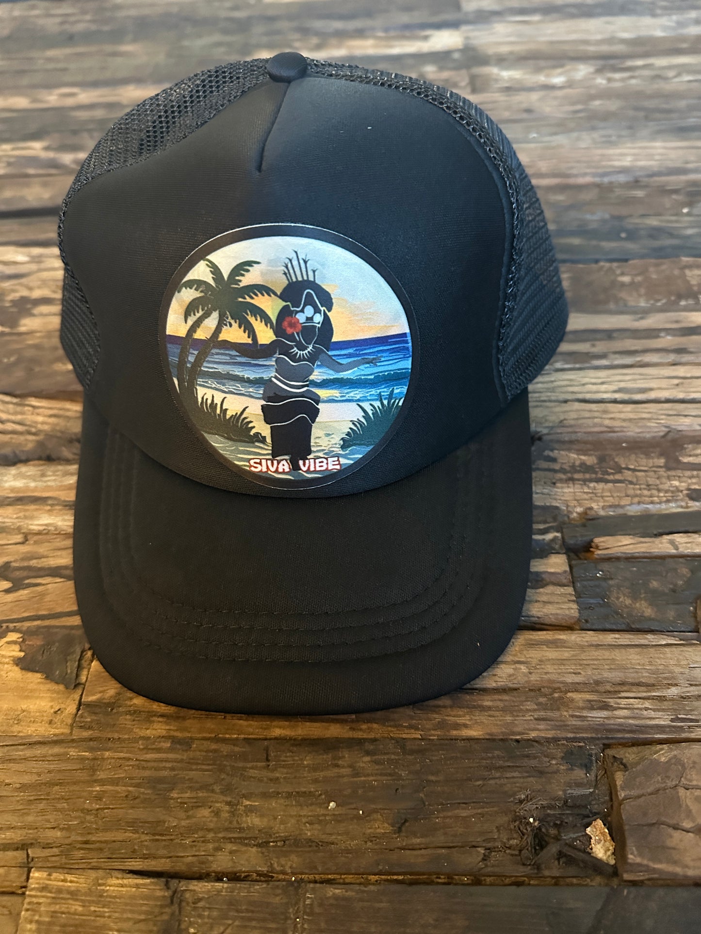 All-black Siva Vibe foam trucker hat with embroidered Samoan Taupou patch — sleek and meaningful island style
