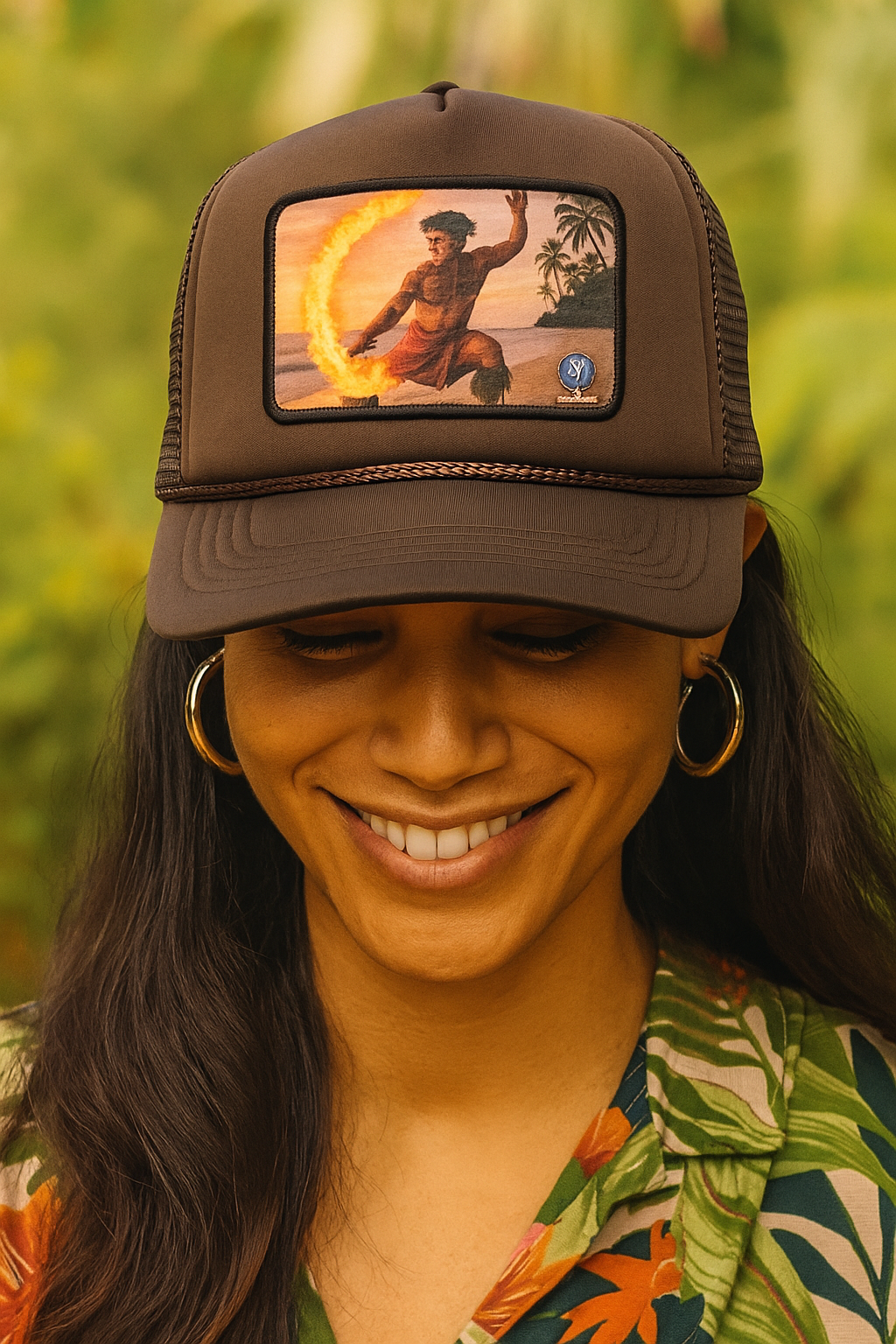 Woman wearing a brown cap with a colorful graphic, outdoors.